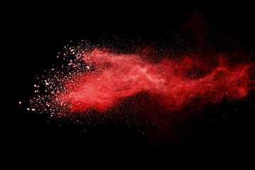 Red powder explosion on black background. Paint Holi.