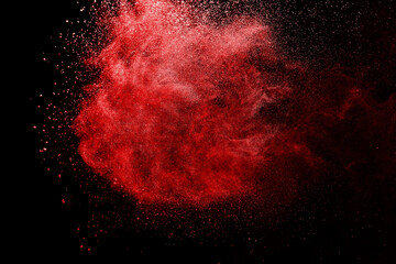 Red powder explosion on black background. Paint Holi.