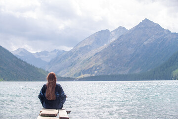 Young woman enjoys the view of  the Multinsky lake. Empty space for text