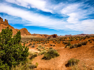 Fototapeta na wymiar Desert landscape with barren land under wide skies and clouds, Arches National Park, UT, USA