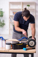Young male repairman repairing skateboard