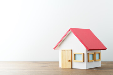 Miniature house on wood table. White background with copy space.