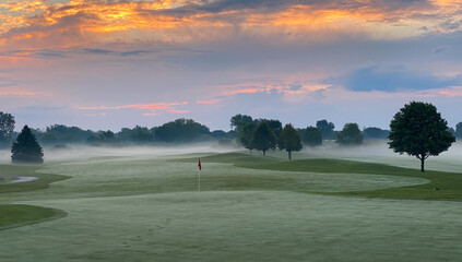 sunrise golf course green red flag late summer early autumn foggy