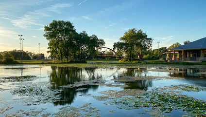 city park pond golden hour lagoon tree reflections bridges