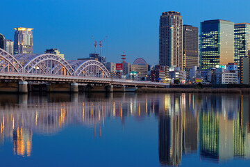 夕暮れの十三大橋と大阪キタの街並み