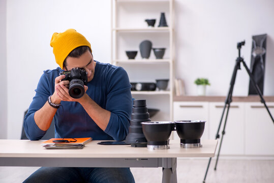 Young male photographer working in the studio
