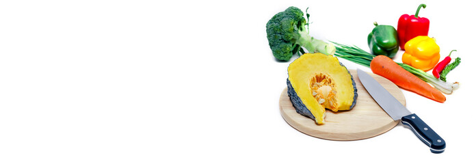 Vegetables and knife on cutting board on white kitchen countertops. Preparing food on white table