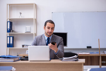 Naklejka premium Young male businessman employee working in the office