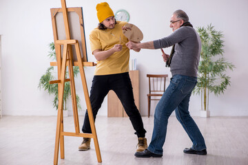 Old man taking lesson from young painter