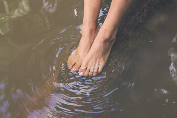 Feet of young girl underwater on a tree trunk