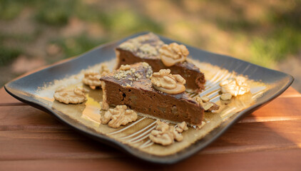Two pieces of pecan pie on an elegant plate. Dessert decorated with walnuts.