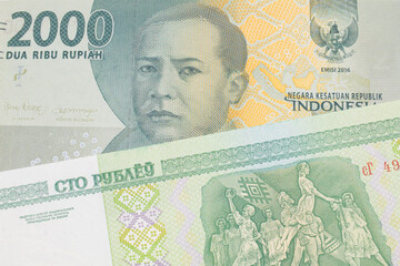 A macro image of a grey two thousand Indonesian rupiah bank note paired up with a green one hundred ruble note from Belarus.  Shot close up in macro.