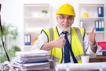 Old male architect working in the office