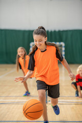 Naklejka premium A girl running with a ball and looking involved