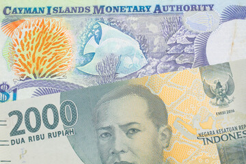 A macro image of a grey two thousand Indonesian rupiah bank note paired up with a colorful one dollar note from the Cayman Islands.  Shot close up in macro.