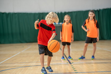 A boy playing with a ball and looking involved