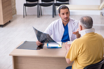 Fototapeta premium Old neck injured man visiting young male doctor radiologist