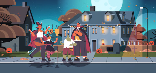 Obraz premium family in different costumes walking in town trick or treat happy halloween celebration concept parents with children having fun horizontal full length vector illustration