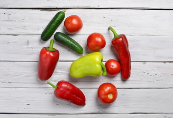 top view of vegetables with tomatoes, cucumbers, pepper on an old wooden light rustic table