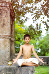 indian priest child doing yoga at park