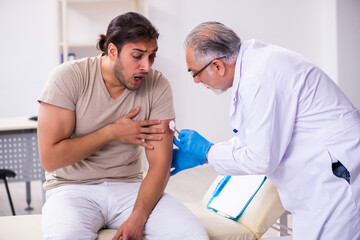 Obraz premium Young face injured man visiting experienced male doctor traumato