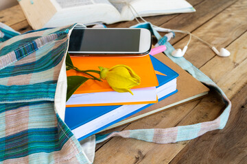 notebook ,diary and mobile phone in cloth bag with dictionary book for study of student arrangement...