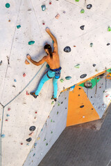 A man is climbing a climbing wall