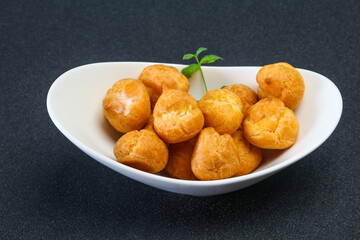 Sweet tasty profiteroles heap in the bowl