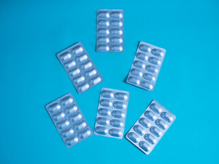 blister pack of pills in capsules on blue background