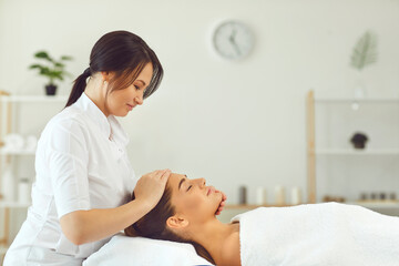 Smiling woman dermatologist making professional manual relaxing massage for young woman