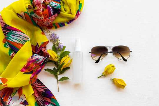 collagen water spray beauty health care for skin face with yellow flower ylang ylang ,yellow scarf and sunglasses of lifestyle woman relax arrangement flat lay style on backround white 