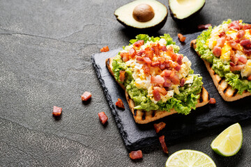 Homemade Toast sandwich with avocado, scrambled egg and bacon. 	