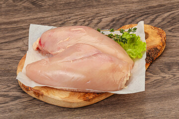 Raw chicken breast over board
