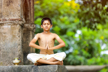 the indian priest child doing meditation