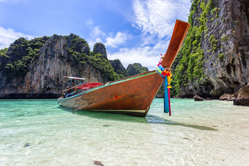 Traditional longtail boat with beautiful scenery view at Pileh Lagoon - Phi Phi Leh Island in sunshine day, Krabi Province, Thailand