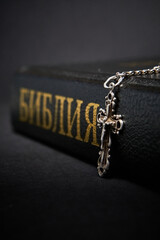 Cross and bible on dark background.