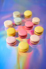 French cake macaron. Set of cute sweets on colorful rainbow background. almond cookies, pastel colors, top view