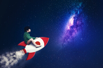 Child riding a rocket while flying on night sky