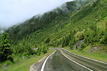 Carretera de montaña entre las brumas de un lluvioso día de verano generando un paisaje de misterio y embrujo. La Transfăgărășan o DN7C es la segunda carretera pavimentada de mayor altitud de Rumania.