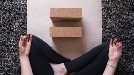 Practising yoga with a block on a beige mat