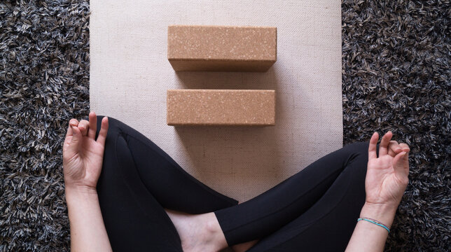 Practising Yoga With A Block On A Beige Mat