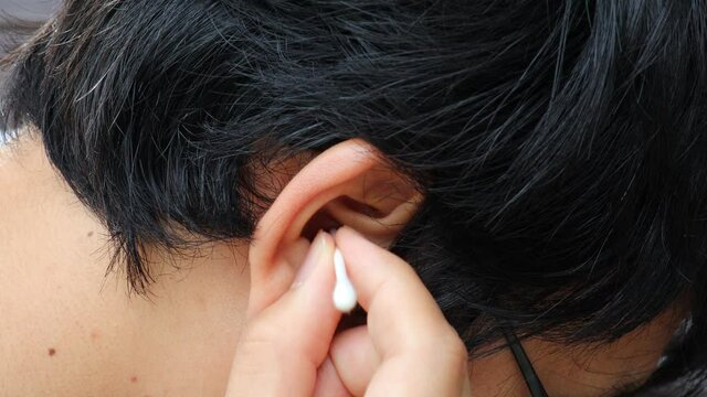 日本人男性が綿棒で耳掃除をしている（横から見た動画）