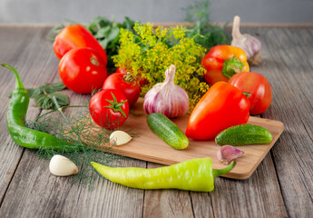 Still life of fresh vegetables. A set of tomatoes, red peppers, cucumbers, garlic and dill. The concept of healthy, vitamin food.