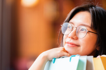 Advertising, Business, Consumerism, Shopping, Lifestyle Concept - Relaxing after day shopping. Asian woman holding shopping bags looking up to the side and leave space for adding your content.