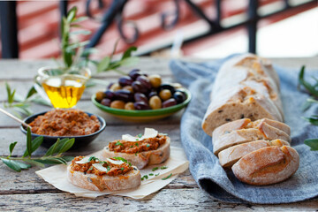 Ciabatta bread crostini, bruschetta with olive tapenade. Wooden background.