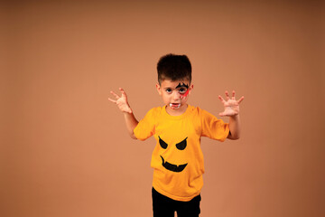 halloween holiday. photo of a boy in a carnival costume on a beige background