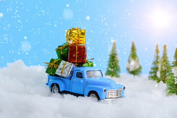 Christmas presents on blue truck riding through a snowy forest