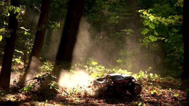 Toy rc car rides in a forest. Radio controlled monster car in the woods. Riding and making smoke dust.