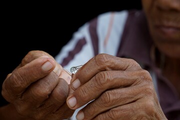 Threading the needle into the hole of the sewing needle using the needle threading device.