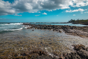 Beautiful shore. Large boulder among the waves in the sea. Hawaii